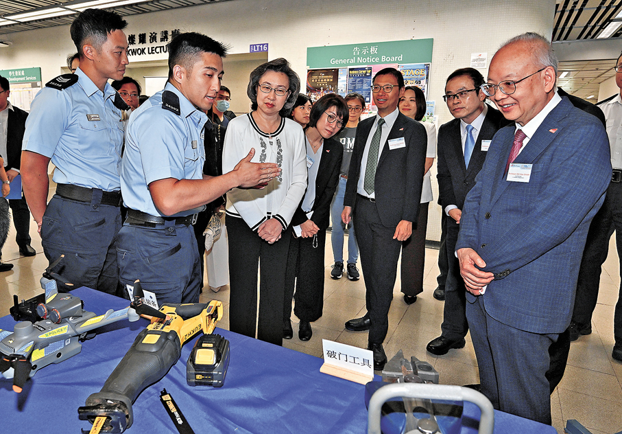 ●楊何蓓茵（前排左三）在香港警務處攤位聽取人員介紹部門裝備。 政府新聞處