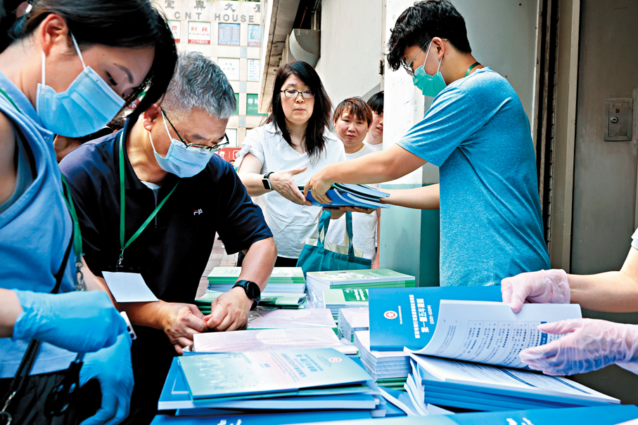 ●市民排隊領取香港第一個五年規劃及2026年施政報告相關文件。 香港文匯報記者黃艾力  攝