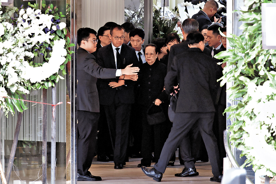 ●董建華遺孀董趙洪娉（中）在次子董立新（左二）攙扶下步出靈堂。中新社