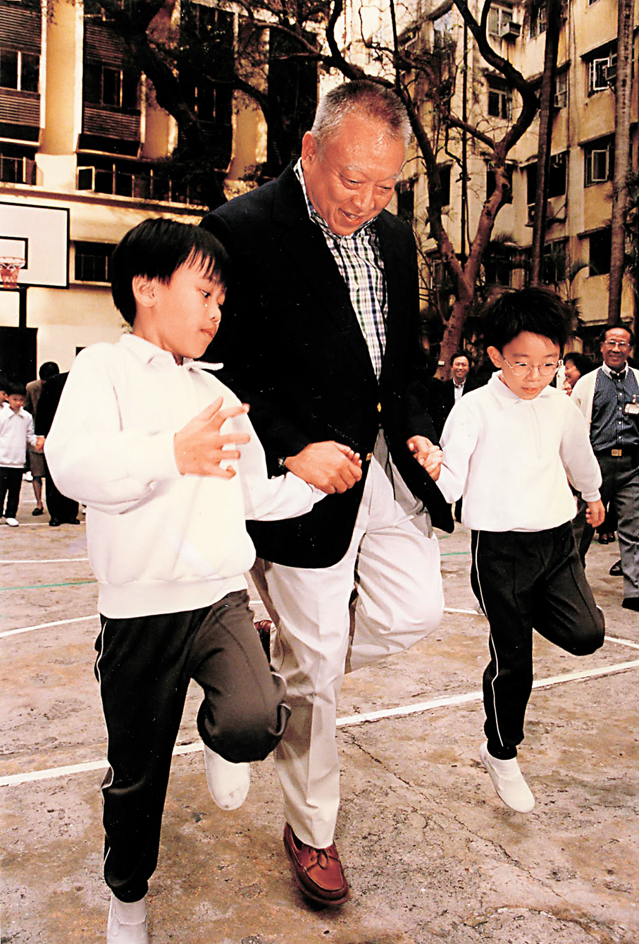●董建華（中）和孩子一起玩。   資料圖片