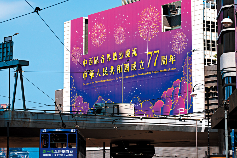 ●臨近國慶日，香港上環一幅外牆掛着橫幅慶祝中華人民共和國成立77周年，洋溢節日氣氛。 中通社