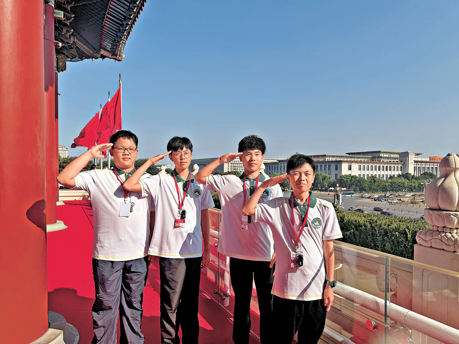 ●參與活動的澳門學子在天安門城樓上向國旗敬禮。 香港文匯報記者鍾佩欣 攝