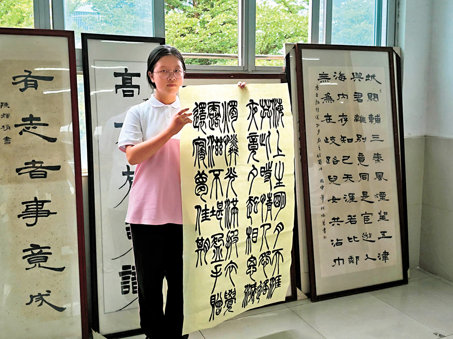 ●港生陳曉瑜以篆書揮毫，把來自大灣區少年的心意寄向天宮。 香港文匯報記者帥誠  攝