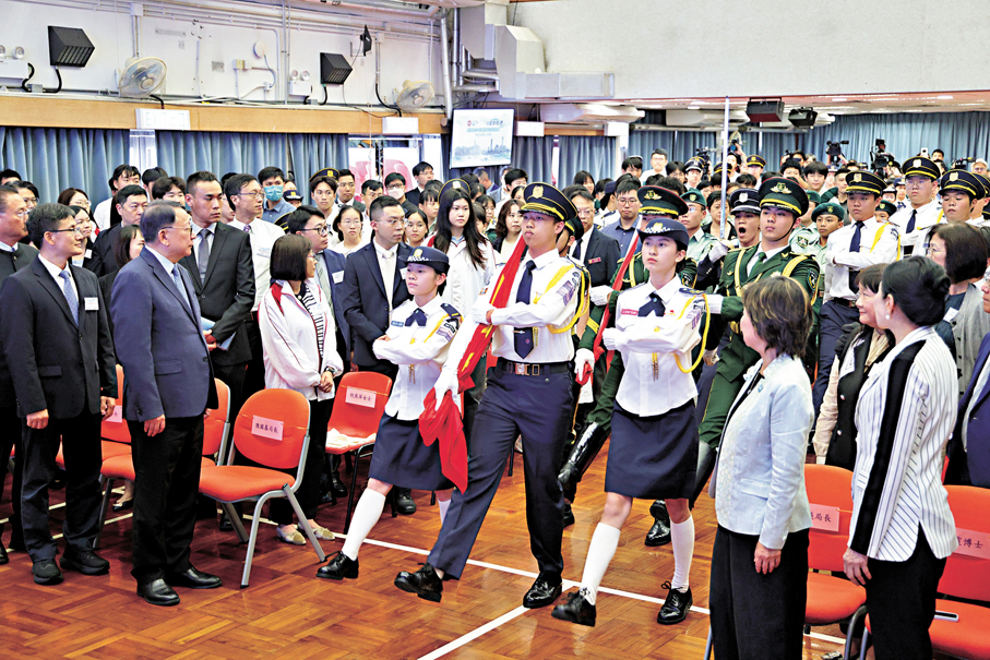 ●「向國旗敬禮」港澳青少年升旗隊代表訪京團在九龍工業學校舉行學習成果分享會，分享在北京的所見所聞所感。圖為升旗儀式舉行。 中通社
