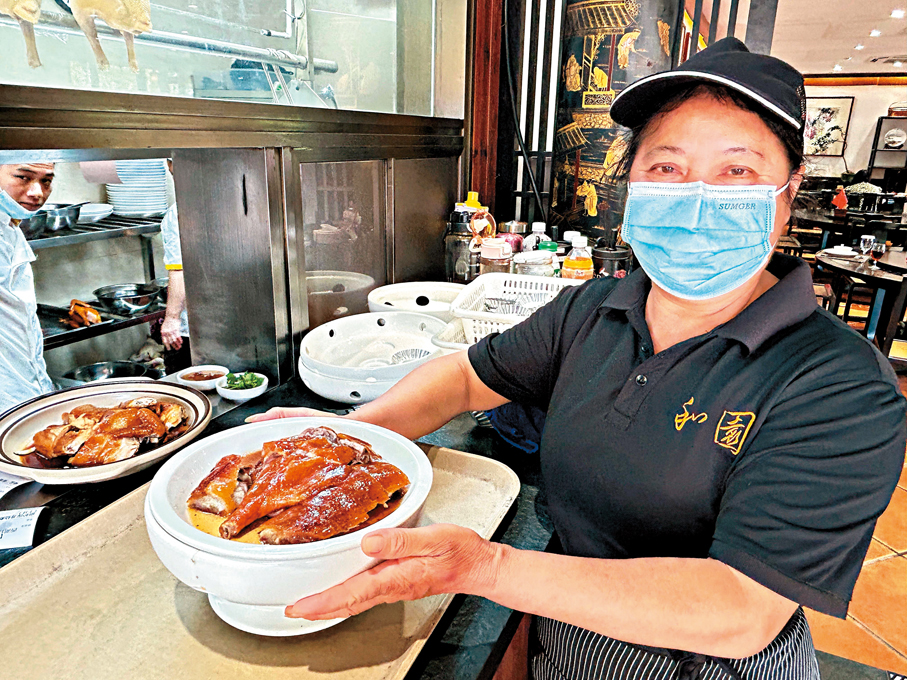 ●燒鵝是港人最喜歡的順德佳餚之一。圖為店員展示特色燒鵝。