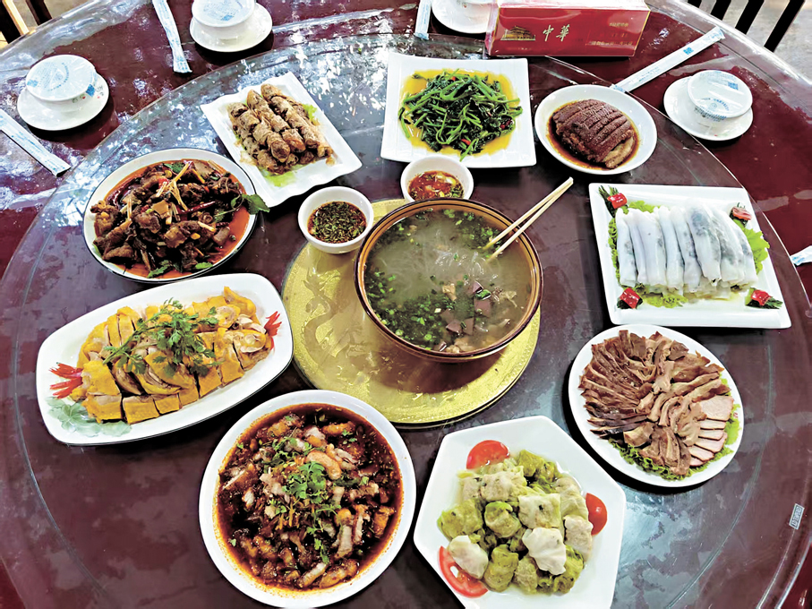 雲南保山柯街華僑社區的「馮家餐館」裏，一盤白切雞靜靜放在白瓷盤中，旁邊兩碟蘸水色澤對比鮮明，一碟深褐醇厚，一碟青綠鮮亮，早早備好等候上桌。