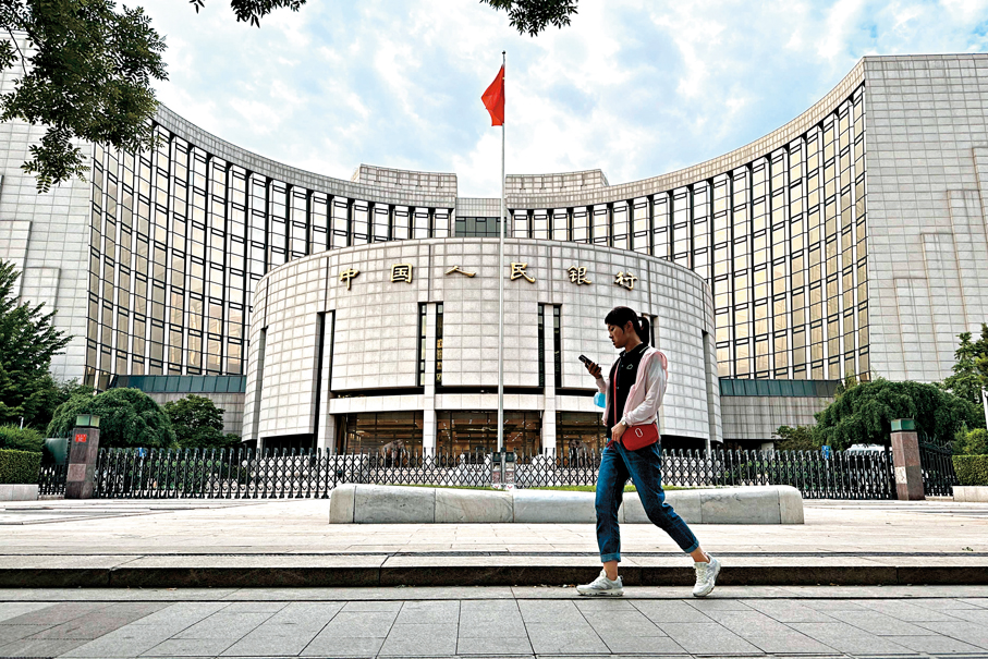 ●央行8日發布關於人民幣匯率的政策立場，系統闡述人民幣匯率形成機制及政策取向。圖為市民路過位於北京的中國人民銀行。  資料圖片