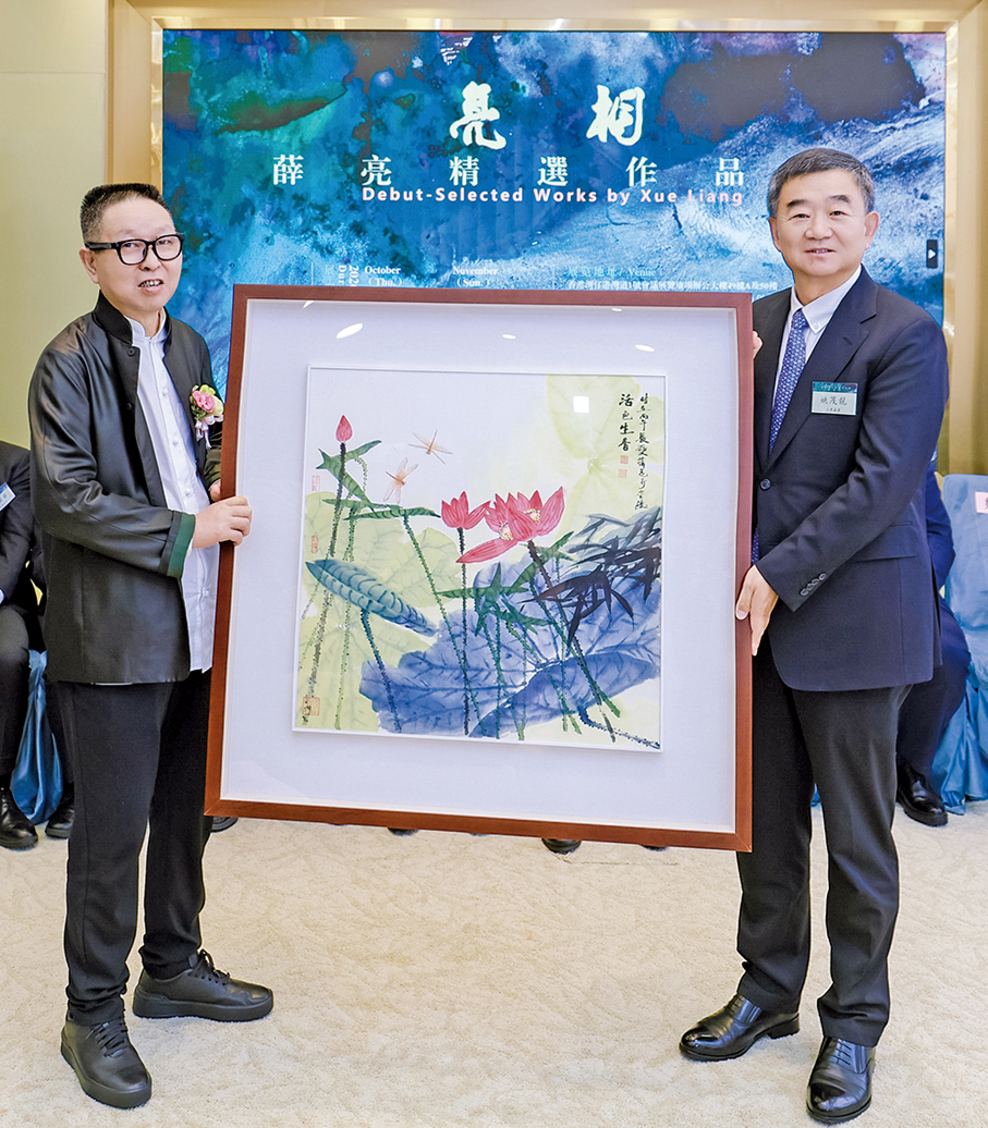 ●薛亮（左）向香港江蘇社團總會捐贈荷花主題畫作，姚茂龍（右）代表接收。