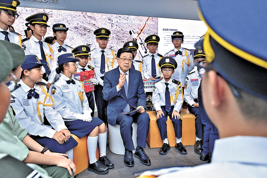 ●李家超（前排右二）聽取「向國旗敬禮」港澳青少年升旗隊代表訪京團團員分享學習成果。 政府新聞處