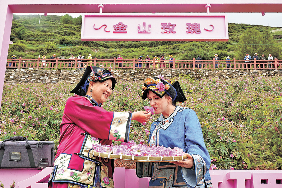 ●「玫瑰姐姐」陳望慧（左）邀請外國友人嗅聞玫瑰。 