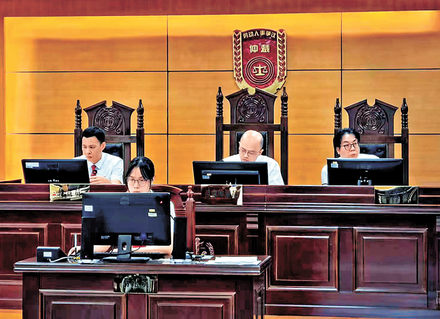 ●早前，香港律師趙志鵬（後排中）以首席仲裁員身份，在南沙審理勞動爭議案件。 資料圖片